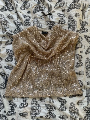 Glittrig guld topp med paljetter - Säljer en glittrig guld topp med paljetter