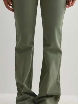 Olivgröna bootcut jeans - Snygga olivgröna bootcut jeans med låg midja och dubbla knappar framtill. Jeansen har klassiska fickor fram och bak samt bälteshällor. Materialet är stretchigt och bekvämt, perfekt för en trendig och avslappnad look.