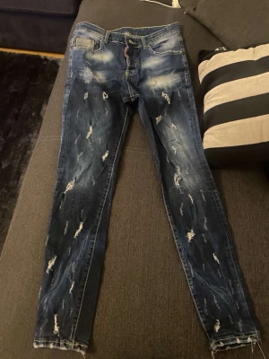 Mörkblå slitna skinny jeans - Säljer ett par mörkblå skinny jeans med slitningar och tvättade detaljer. Jeansen har klassisk femficksmodell och dragkedja med knapp. Snygg streetstil som passar perfekt till en avslappnad look.