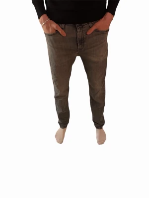 Grå jeans Levi's - Säljer ett par grå jeans från Levi's med klassisk femficksdesign och rak passform. Jeansen har en snygg tvättad look och detaljer som synliga sömmar och Levi's ikoniska röda etikett på bakfickan. Perfekta för en avslappnad stil.