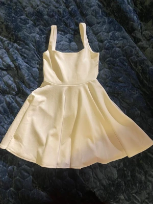 Vit klänning med rosett - Supersöt vit klänning från Lucy in the sky med axelband och band som man kan knyta till en rosett i ryggen. Perfekt för studenten eller midsommar. Klänningen har fyrkantig urringning och är tajt upptill, kjolen är utsvängd och får ett fint fall på. Nypris är ca 600kr. Storlek är S men är relativt liten samt stretchigt material så passa nog även XS. För mig slutar kjolen på halva låret Säljer då den blivit för liten för mig. Skriv ifall det finns några frågor💞