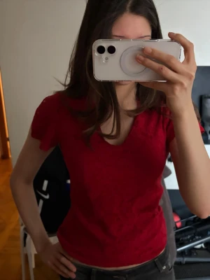 Röd spetsblus med öppna ärmar - Snygg röd blus i spets med v-ringning. Figurnära passform som framhäver siluetten. Perfekt för dig som vill ha en feminin och trendig topp till jeans eller kjol.