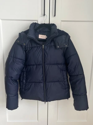 Mörkblå pufferjacka från Nelly - Säljer denna jacka från Nelly då den inte kommer till användning längre. Köpt förra året men är fortfarande i väldigt bra skick. Varm och gosig💕