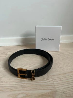 Svart Läder bälte med guld logga  - Superä stiligt svart läder bälte med guld detaljer. 90 cm långt. Skriv om du har några frågor! 😊