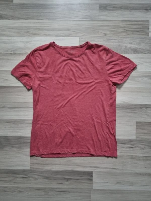 Roströd basic t-shirt i bomull - En enkel roströd t-shirt med rund hals och korta ärmar. Tillverkad i mjuk bomull, perfekt för en avslappnad och stilren look. Passformen är normal och färgen har en lätt matt ton.