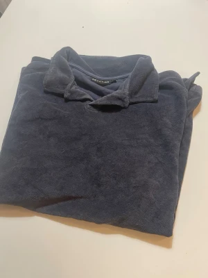 Mörkblå fleece-tröja med krage - Mysig mörkblå fleece-tröja från BRAXTON med klassisk krage och lång ärm. Perfekt för kyliga dagar när du vill ha något både bekvämt och stilrent. Enkel design som passar till det mesta.