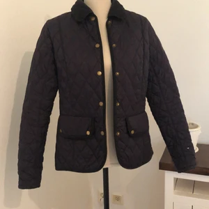 Jättefin Barbour jacka - Superfin jacka från Barbour i storlek 38, men passar mig bra som oftast är en storlek 36. Den är mörkblå och quiltad och i superbra skick. Det enda är att det finns ett litet litet hål på vänstra ärmen (syns på bild 2). Paketet kan postas, men då får du stå för frakten. 