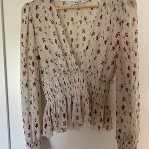 Blommig topp Na-kd  - En fantastiskt fin och somrig topp från Na-kd i storlek 36.