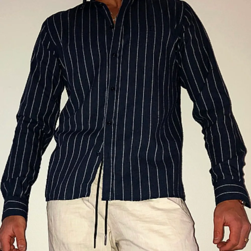 Bekväm stretchig skjorta ifrån Les Deux med 70% bomull och 30% polyester med bra pass form. Skjortan är något lång i varianten och kan med uppknäppta knappar vid armarna bli till en mer luftigare skjorta och i samma fall bli en mer slimmad skjorta med knapparna knäppta. Med material som är 70% bomull blir skjortan mycket bekväm och mjuk att ha på sig.. Skjortor.