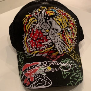 Ed Hardy keps svart - en svart ed hardy keps som jag köpt här på plick. Den är i helt ny skick och endast använd i bilderna till annonsen. Som jag visar på baksidan av kepsen kan man ändra storleken så du behöve inte oroa dig det🤩🧢