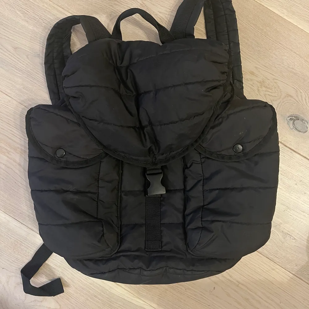 Vadderad ryggsäck i svart, från Uniqlo. Väskor.