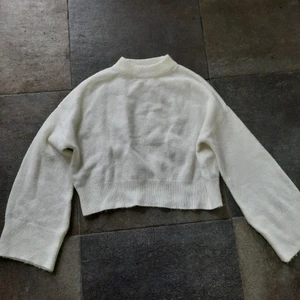 Stickad tröja - Vit stickad tröja med vida ärmar från nakd i storlek xxs. Töjbar och stor i storleken. Passar därför xxs-s skulle jag säga beroende på hur man vill att den ska sitta