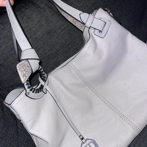 Grå snygg handväska - Säljer denna skit snygga rymliga handväska med detaljer. Är som en mjuk handväska, dvs kan den inte stå själv