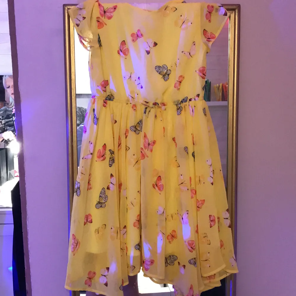 En gul kortärmad klänning med fina färglagda fjärilar!. Klänningar.