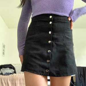 Svart kjol från Gina Tricot med knappar framtill. 
