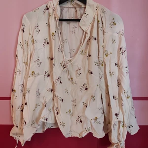 Blommig blus - Lite skrynklig nu, men är annars fin och slät. Snörning runt halsen och blommor över hela 