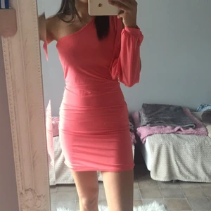 Peach/rosa färgad one shoulder kläning - Peach/rosa färgad one shoulder kläning men öppen arm. Använd max 2 gånger och är i jätte bra skick