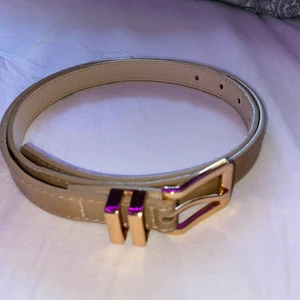 Beige skärp med guldiga spänne!  - Jag säljer ett beige skärp med guldiga spänne. Oklart vad det är för storlek men det passar mig om jag har på någon av de ”minsta” hålen. Skärpet är använd bara ett fåtal gånger. Det är köpt på GinaTricot. 