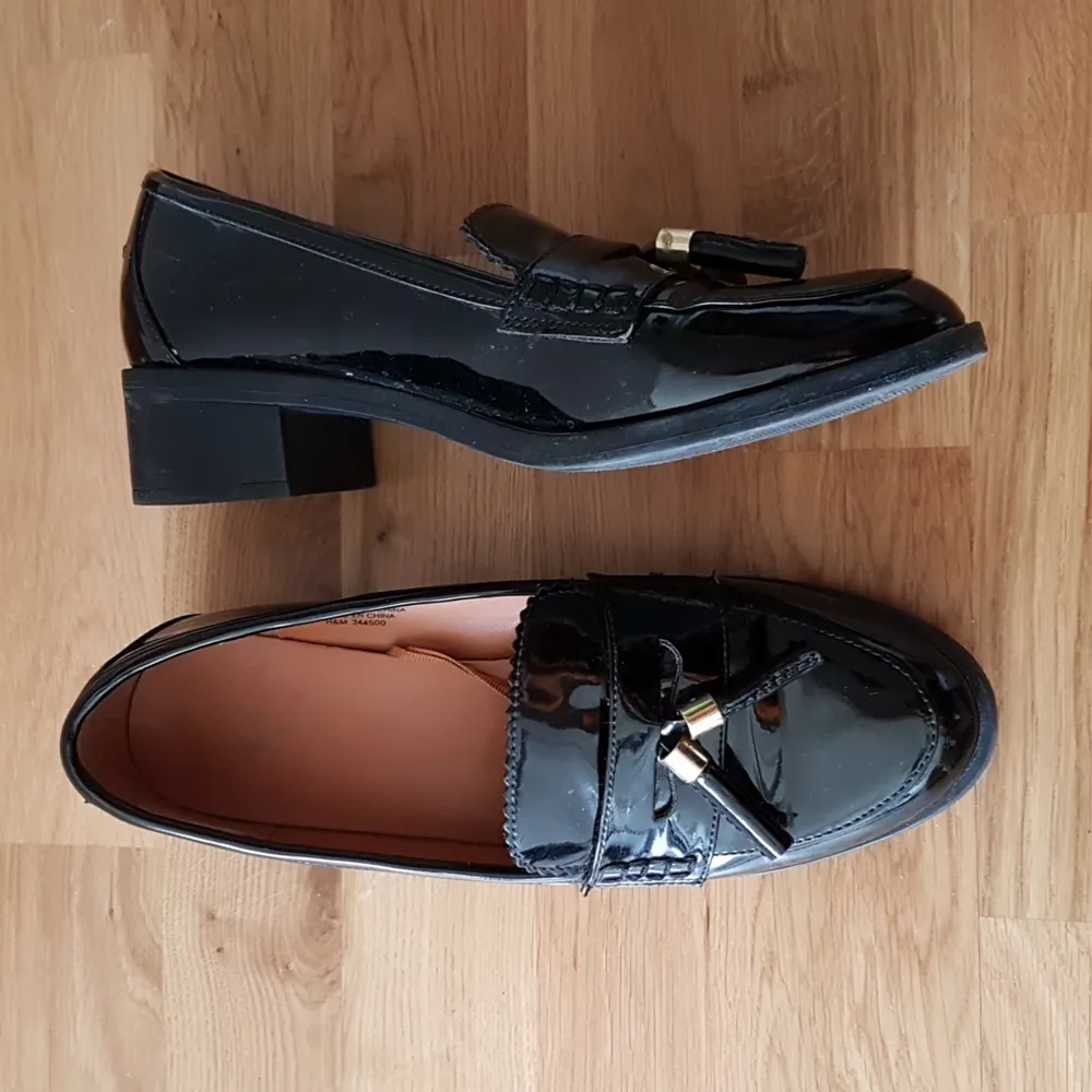 Snygga lackade loafers från H&M i storlek 39 med små guldtaljer framtill. Använda men i fint skick, sånär som på några skavmärken som uppstått när skorna har gruggats mot varandra. Finns att hämta i Göteborg eller skickas mot betalning 😊. Skor.