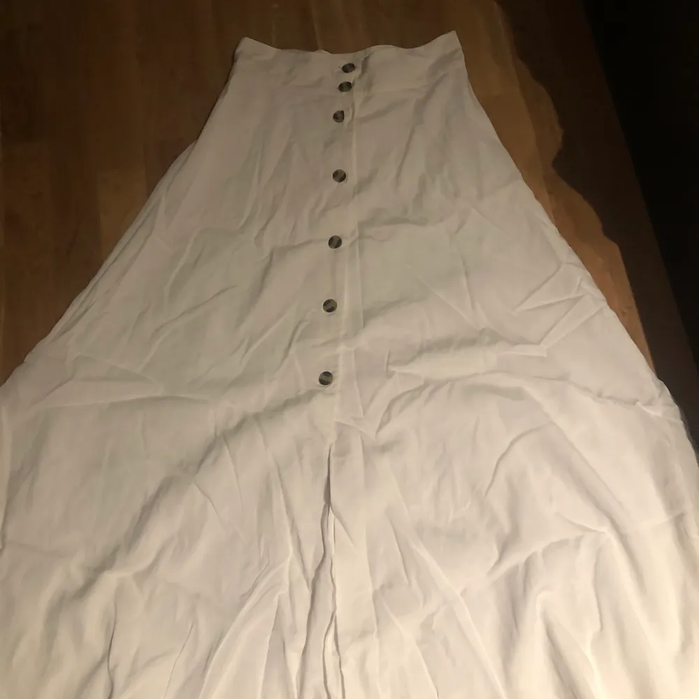 En jätte fin vit maxi kjol från HM, köpt förra sommaren, aldrig använd. Bruna knappar i fram. I storlek 36. Kjolar.