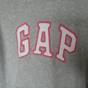 GAP Grå med Rosa bokstäver - GAP hoodie, Grå med rosa och vita bokstäver. Står strl M men sitter som en S. Välanvänd men bra skick