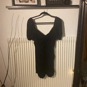 Oanvänd klänning i perfekt skick! - Supersnygg svart klänning med puffärmar och rynchning längs med kroppen som ger en snygg figur. Aldrig använd då tillfälle inte hittats, så nu får den vandra vidare. Strl L men passar strl 36-38 i verkligheten. Köpare står för frakt, endast uppskattat pris längre ner!