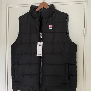 Fila Väst - Fila Väst (Vändbar) Style: Gunnar                                                    Skick: 10/10 (Oanvänd)                                                               Ordinarie pris: 650kr Mitt pris: 400kr                                                 Hör av er för fler bilder och info!