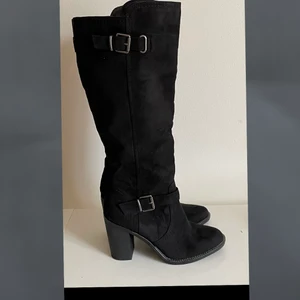 NYA stövlar -Stl 37 - Helt nya stövlar i svart mocka - med spänne detaljer - stängs igen med blixtlås hela vägen upp. Breda i vaden för skön comfort. 