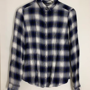 Skjorta dam - Rutig skjorta i en avslappnan modell. Köparen står för frakten.