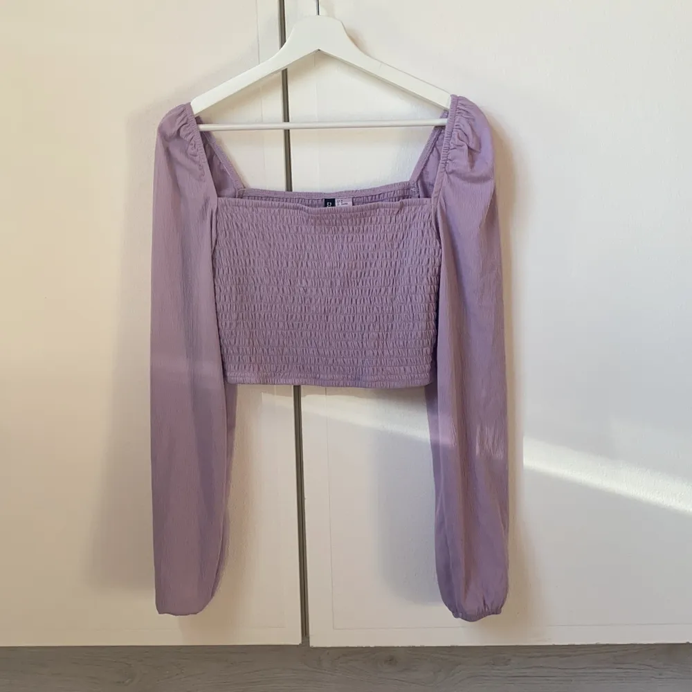 En croppad lila tröja från HM som aldrig är använd, den är i storlek M och i mycket fint skick. 40kr + frakt ☺️. Toppar.