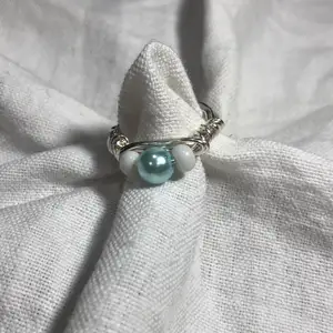 En hemmagjord ring med två små vita pärlor och en stor ljusblå pärla. Passar bra till mycket. 70kr med frakt!🚚
