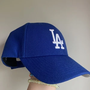 Blå Keps - Skit snygg blå LA keps! Justerbart med resår där bak. Använd endast 1 gång. Säljer då den inte kommer till användning!💙💙 köpare står för frakt 