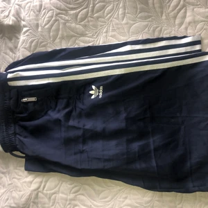 Adidas idrottsbyxor - Utsvängda adidas byxor, marinblåfärg och passar en 38/165 cm. 