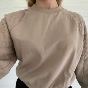 En fin beige sweatshirt från ginatricot med rutiga detaljer på axlarna. Den är vi bra skick och nästan helt oanvänd. Storlek:S🤎