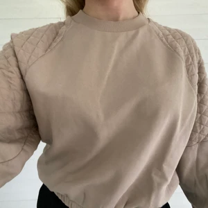 Ginatricot beige sweatshirt - En fin beige sweatshirt från ginatricot med rutiga detaljer på axlarna. Den är vi bra skick och nästan helt oanvänd. Storlek:S🤎