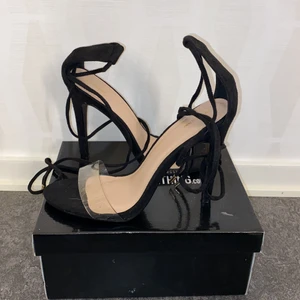 Klackskor - Supersnygga klackar från prettylittlething i storlek 38. De har svarta snören med gulddetaljer som man ska snurra runt benet. Använda två gånger. Säljer på grund av att de inte kommer till användning.