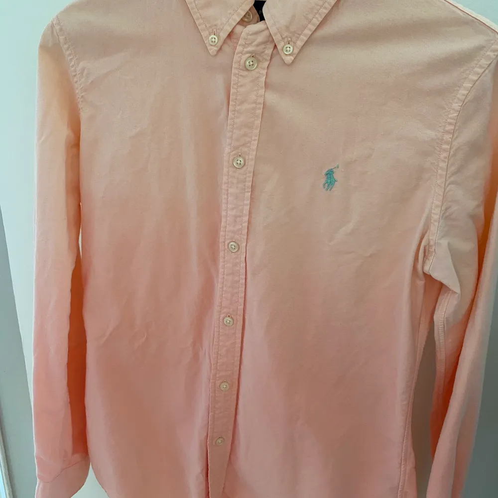 Skjorta från Ralph Lauren i en orange korall färg. Fade effekt dvs ljusare upptill och mörkare nedtill. Storlek: Small, custom fit. Fint skick. Ord pris 1200 kr. Skjortor.