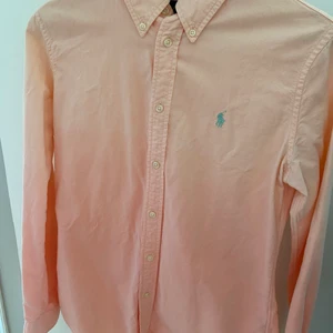 Ralph Lauren skjorta Dam  - Skjorta från Ralph Lauren i en orange korall färg. Fade effekt dvs ljusare upptill och mörkare nedtill. Storlek: Small, custom fit. Fint skick. Ord pris 1200 kr