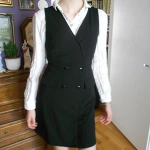 Charmig liten pinafore klänning ⛪ - Otroligt söt pinafore klänning i stretchigt svart tyg. Knälång, fickorna är faux. Älskar denna så mycket! Storlek S 📚 OBS om du köper mer än ett plagg är frakten gratis! 