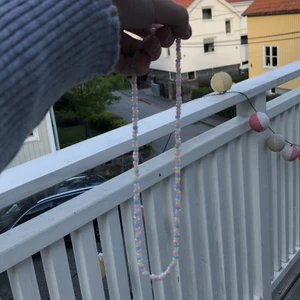 Ett pärl hals band med ljusa färger - Päl hals band med gul,blå och rosa pastel färger, Ni får järna kontakta oss om ni undrar nåt.