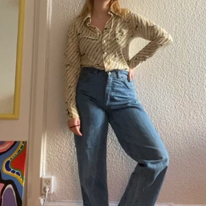 70-talsskjorta med HUNDMÖNSTER - Nejmen hör av er dagen ni hittar ett coolare plagg än detta? Det är alltså en 70-talsskjorta med otrolig krage i typisk 70-talsstil med hundmönster och koppel på??? En kompis hittade den i en utförsäljning av dramatens kostymföråd, och sedan fick jag den. Älskar den, funderar ofta på vilken föreställning den kan ha vart med i. Den e storlek S, men den e ganska tight. Skulle säga S/M men det beror väll på hur man vill att den ska sitta. Tycker att det är den ultimata skjortan, grattis.