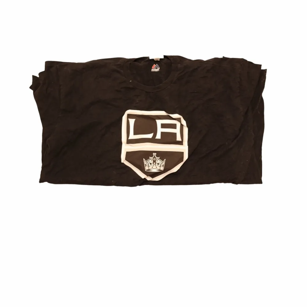 En riktigt fet svart tröja frn hockeylaget i USA som heter LA kings. Trycket är deras logga och den är svart och vit. Sjölv materialet har hög kvalitet och är svart. Thriftad på en secondhandbutik i USA.. T-shirts.