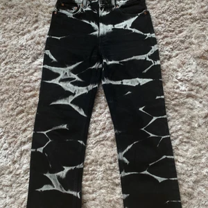 Svarta jeans med vita detaljer - Coola jeans från weakday i st 27/30. Endast använd några få gånger så är som i nytt skick 