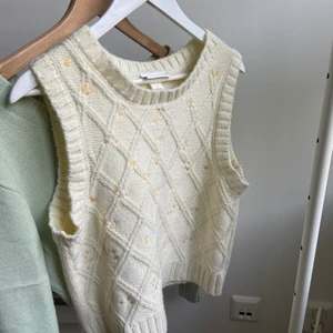 Stickad väst  - Denna superfina beiga väst, har små vita blommor och är i ett fint, och bekvämt stickat material. Västen kommer ifrån Monki, och är i storlek L, den passar dock alla storlekar beroende på hur man vill att den ska sitta❤️