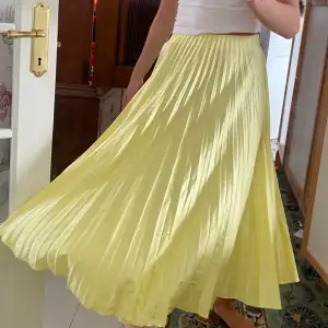 Plisserad gul silkes kjol med fin längd. Jag är 164cm lång