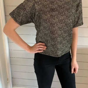 Festlig T-shirt från Gina tricot i stl S - Guldskimmrig svart T-shirt, passar bra på mig som har storlek S och är 160 cm lång. Passar XS till M beroende på passform. Använd typ 2 gånger så den är i nyskick. Köpare står för frakt
