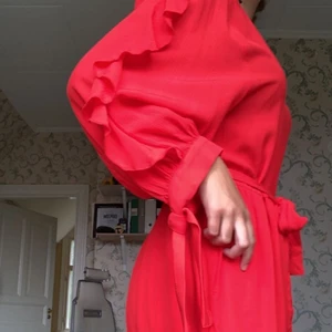 Röd byxdress med volanger och knyten - Riktigt fin byxdress med volanger på ärmarna! Storleksmässigt fungerar den för både medium och small då den går att knyta i midjan och på ärmarna. Hör gärna av dig efter fler bilder etc! 