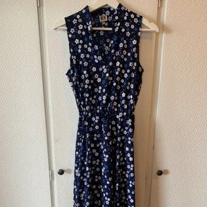Knälång klänning - Knälång blommig marinblå klänning. Nyskick. Tunn i materialet. Insytt ”skärp” i midjan