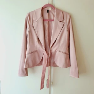 Rosa kostym i siden - Vacker kavaj i rosa siden. Kavajen har en matt glans & knyts med en rosa glansig rosett. Oversized på mig men skulle sitta nätt & fint på någon med strl M eller L😍Figursydd 42:a i absolut gorgeous skick✨ Pris: 240 + frakt🥰