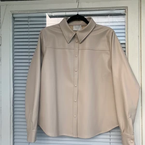 FAUX skinnjacka - Faux (konstläder, alltså fejk) skinnjacka/skjorta säljes. Aldrig använd, från märket neo noir. Strl: L men upplever den mer som en one size beroende på hur man stylear den. 